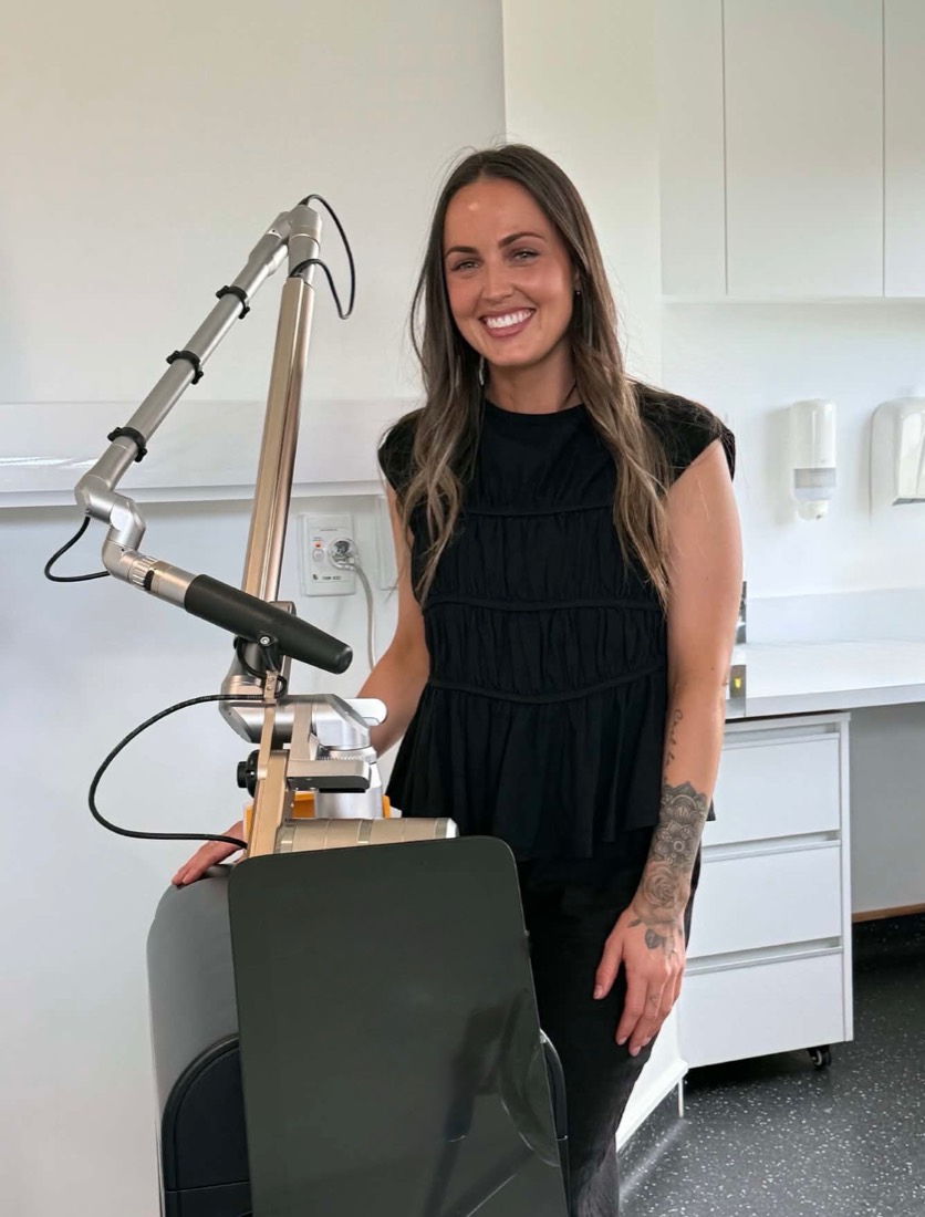 Sarah, who runs The Laser Co., standing beside the Zenith Excelsior laser in the Paraparaumu studio.
